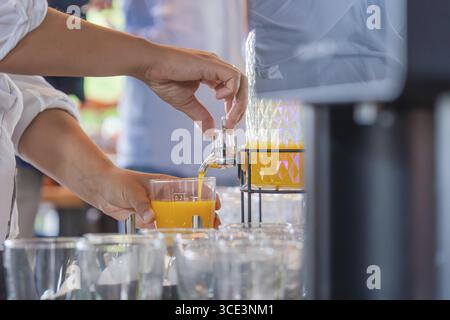 Succo d'arancia versato da un dispenser in un bicchiere, brewhouse Schoenbuch, Boeblingen, Germania Foto Stock