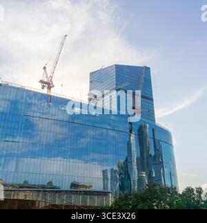 moderno edificio per uffici in costruzione sullo sfondo blu del cielo Foto Stock