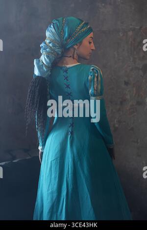 Splendida signora in stile spagnolo con abito blu brillante e sciarpa decorata, ritratto alla moda medievale. Foto Stock