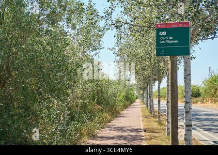 Viladecans. Barcellona - 15 agosto 2025: L'immagine mostra un sentiero per passeggiate a piedi e in bicicletta, con un cartello che indica il nome del percorso, promuovendo l'outdoo Foto Stock