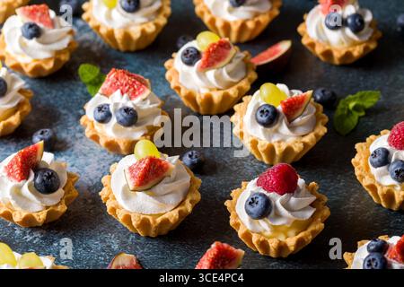 Cestino di frutta frolla. Panna montata, frutta fresca, fichi, uva lamponi mirtilli Foto Stock