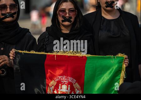 Madrid, Spagna. 15 agosto 2025. Le donne con nastro in bocca protestano in silenzio contro la perdita dei diritti fondamentali per donne e ragazze in Afghanistan. Il 15 agosto segna quattro anni da quando i talibani sono tornati al potere in Afghanistan. Crediti: Marcos del Mazo/Alamy Live News Foto Stock