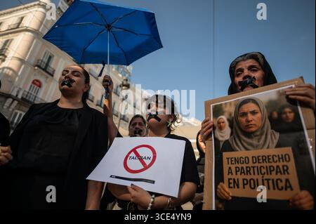 Madrid, Spagna. 15 agosto 2025. Le donne con nastro in bocca protestano in silenzio contro la perdita dei diritti fondamentali per donne e ragazze in Afghanistan. Il 15 agosto segna quattro anni da quando i talibani sono tornati al potere in Afghanistan. Crediti: Marcos del Mazo/Alamy Live News Foto Stock