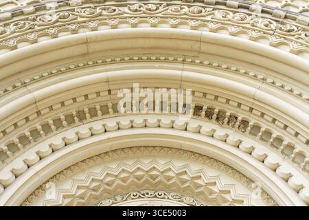 Primo piano di ornati archi in pietra con modanatura decorativa all'ingresso dell'University College. Foto Stock
