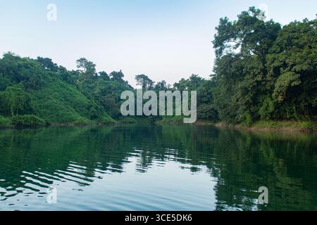 Tranquille colline verdi smeraldo che si riflettono pacificamente sulle calme acque del lago Kaptai a Rangamati Foto Stock