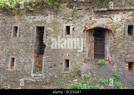Primo piano di mura in pietra intemprata con finestre a sbarramento nella fortezza di Owcza Góra a Kłodzko, Polonia Foto Stock