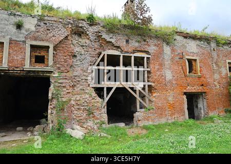 Muro di mattoni rossi sbriciolato con rinforzo in legno nella fortezza abbandonata di Owcza Góra a Kłodzko, Polonia Foto Stock