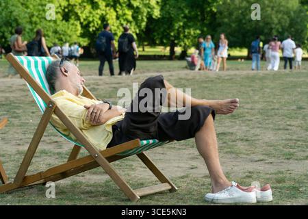 Meteo nel Regno Unito, 15 agosto 2025: Quando le temperature nel centro di Londra raggiunsero di nuovo i 29 gradi, Green Park offrì aria fresca e la possibilità di rilassarsi su una sedia a sdraio. Crediti: Anna Watson/Alamy Live News Foto Stock
