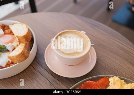 Vista dall'alto delle uova strapazzate e del salmone affumicato, con caffè latte e colazione shakshouka Foto Stock