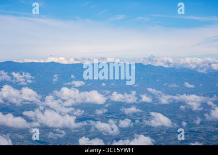 Splendida vista aerea del paesaggio colombiano che mostra le catene montuose e le soffici nuvole sotto un cielo azzurro. Foto Stock
