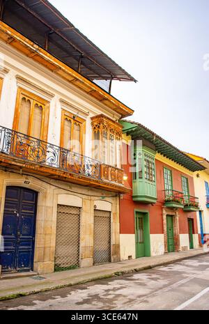 Affascinanti edifici coloniali con colori vivaci e dettagli intricati su una strada di Bogotá, Colombia. Ideale per viaggi e temi architettonici. Foto Stock