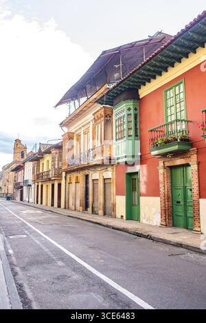 Affascinanti edifici coloniali fiancheggiano una strada tranquilla a Bogotá, Colombia, con colori vivaci e ricchi dettagli architettonici. Foto Stock