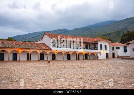 Un pittoresco scenario di una piazza storica a Villa de Leyva, Boyaca, Colombia, caratterizzata da architettura coloniale e strade acciottolate. Foto Stock