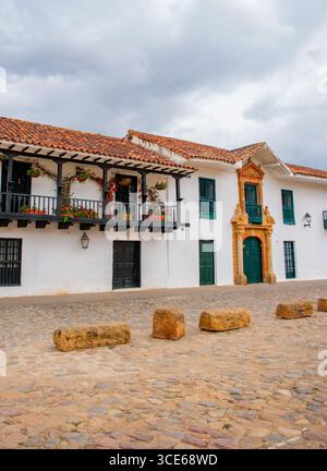 Vista panoramica degli edifici coloniali di Villa de Leyva, Boyaca, Colombia, con vivaci vasi di fiori e strade acciottolate. Foto Stock