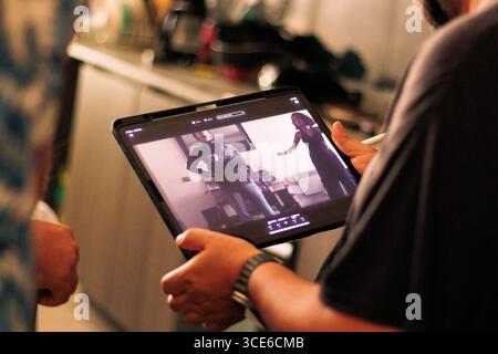 Dietro le quinte di una produzione audiovisiva, registrando film e monitorandoli attraverso schermi e telecamere. Del direttore e del team di produzione Foto Stock