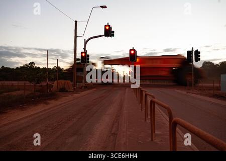 dumper da miniera attraversamento di semafori in moto al crepuscolo pericoli di guida segnali di arresto in accelerazione in ingresso all'incrocio scarsa luce abbagliante visibilità ridotta wei Foto Stock
