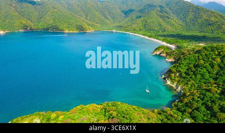Splendida vista aerea della Baia di Santa Marta, circondata da lussureggianti montagne verdi e acque cristalline a Magdalena, Colombia. Foto Stock