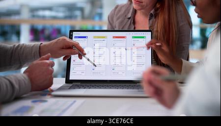 Gruppo diversificato di giovani professionisti che collaborano al software in Office. Foto Stock