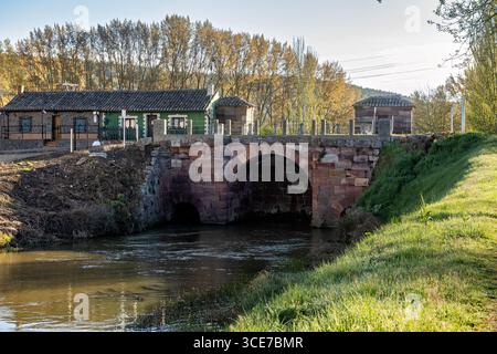 Antico sistema di chiuse del Canal de Castilla nell'Alar del Rey che si riflette sulle acque calme Foto Stock