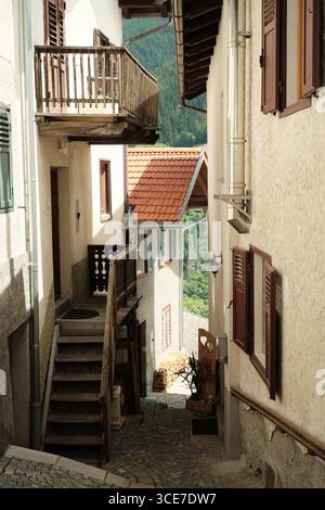 Vicolo acciottolato con tradizionali case alpine a Stilfs, alto Adige Foto Stock