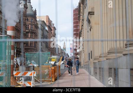 12 agosto 2025, St. Vincent Street, centro di Glasgow, Scozia. Gli extra cinematografici corrono lungo la strada come parte delle riprese dell'ultimo film di Spider-Man. Foto Stock