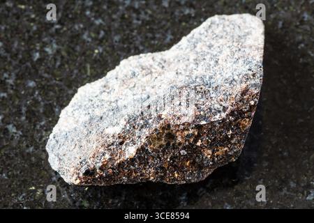 Assaggio di minerale di phlogopite grezzo su fondo di granito nero da vicino dalla penisola di Kola, Russia Foto Stock