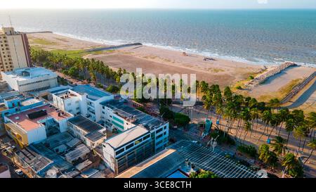 Vista aerea di un'area costiera di la Guajira, Colombia, caratterizzata da spiagge sabbiose e architettura urbana contro l'oceano. Foto Stock