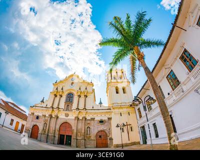 Splendida vista degli edifici coloniali con palme a Popayán, Cauca, Colombia, sotto un cielo blu brillante. Foto Stock