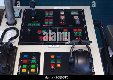Un pannello di controllo per una nave marittima con vari pulsanti, leve e interruttori. Foto Stock