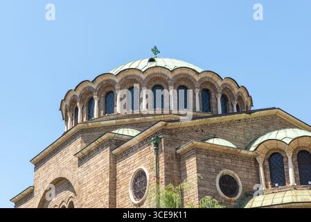 Vista ravvicinata della cupola e delle finestre ad arco della chiesa di Santa Nedelya, Sofia, con dettagli in pietra e tetto verde in rame Foto Stock