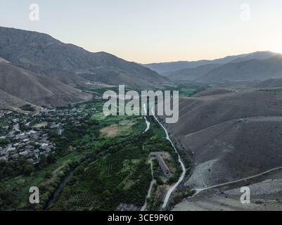 Vista aerea della luce del sole dorata che bacierà le aspre vette che circondano la valle verdeggiante e il fiume serpeggiante, Areni, provincia di Vayots Dzor, Armenia. Foto Stock