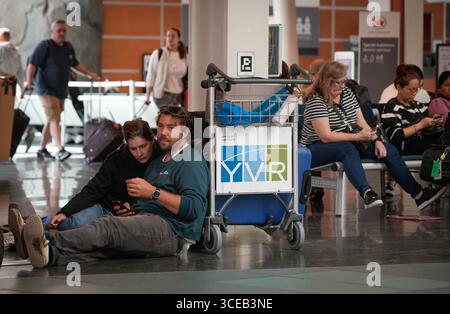 Richmond, Canada. 16 agosto 2025. Le persone aspettano fuori dall'area di check-in di Air Canada all'Aeroporto Internazionale di Vancouver a Richmond, British Columbia, Canada, 16 agosto 2025. La più grande compagnia aerea canadese Air Canada ha dichiarato di aver sospeso tutte le operazioni di Air Canada e Air Canada Rouge a causa di uno sciopero dei suoi 10.000 assistenti di volo. Circa 130.000 clienti saranno colpiti ogni giorno che lo sciopero continua, ha detto la compagnia aerea. Crediti: Liang Sen/Xinhua/Alamy Live News Foto Stock