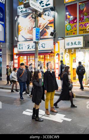 La gente che camminava sulla trafficata strada pedonale in Shibuya, Tokyo, Honshu, Giappone Foto Stock