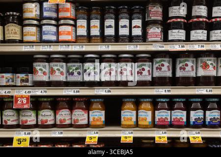 Davis, CALIFORNIA, Stati Uniti. 11 agosto 2025. Scaffale del supermercato con varie marche di preervo e marmellate, con cartellini dei prezzi sotto di essi Foto Stock
