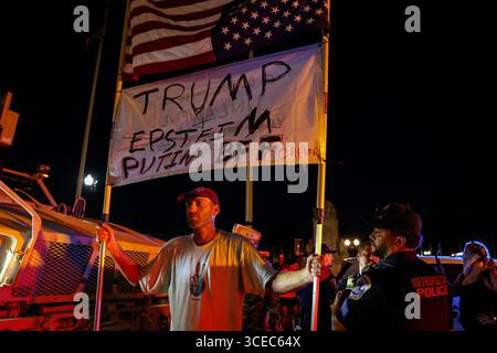 Washington, District of Columbia, USA. 16 agosto 2025. Un manifestante si trova di fronte a un veicolo militare mentre un ufficiale della polizia metropolitana lo avverte di lasciare vicino alla Union Station il 16 agosto 2025, a Washington, il presidente Donald Trump ha annunciato i piani per dispiegare gli ufficiali federali e la Guardia Nazionale nel distretto, con l'obiettivo di porre il Dipartimento di polizia metropolitana di Washington sotto il controllo federale e assistere gli sforzi di prevenzione del crimine nella capitale della nazione. Crediti: ZUMA Press, Inc./Alamy Live News Foto Stock