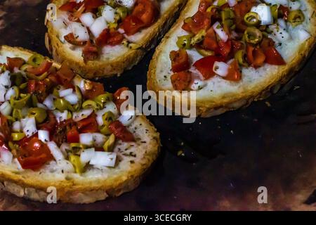 Primo piano della bruschetta con pomodori, olive e cipolle sul pane rustico Foto Stock