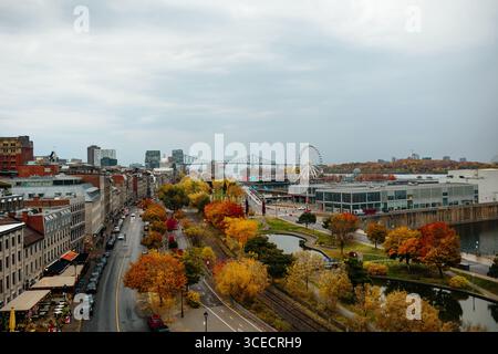Vista panoramica della città di Montreal con una splendida esposizione di fogliame autunnale. La ruota panoramica e il ponte Jacques Cartier si distinguono tra i vivaci Foto Stock