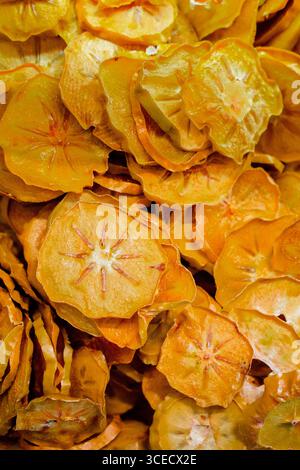 Una vista ravvicinata delle pesche secche, mostrando le loro ricche sfumature dorate e le fette di consistenza. Questa immagine cattura la bellezza naturale e i dettagli intricati Foto Stock
