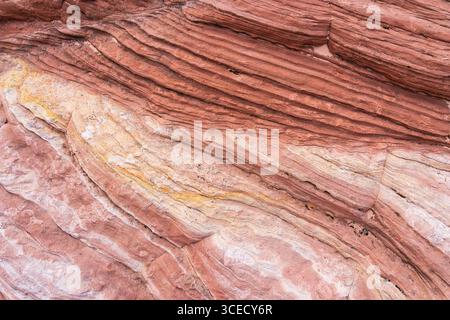 Struttura astratta in arenaria che mostra formazioni a strati in delicate tonalità della terra, evidenziando scanalature e motivi naturali. Ideale per sfondi, de Foto Stock