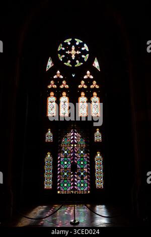 Cantabera, Spagna - 13 Feb 26: Una grande vetrata decorata con motivi intricati e colori vivaci, incastonata in una cornice scura ad arco. Foto Stock