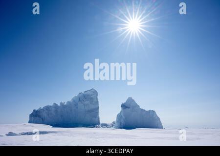 Parco nazionale della Groenlandia nord-orientale, il più grande parco nazionale del mondo. L'unico parco nazionale della Groenlandia. Iceberg collegato a terra con scoppio di sole. Foto Stock