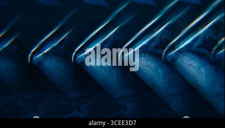 Onda di vernice. Angolo geometrico. Le particelle lucide di colore viola blu scorrono il pigmento dell'acqua che galleggia su uno sfondo astratto al neon art acrilico. Foto Stock