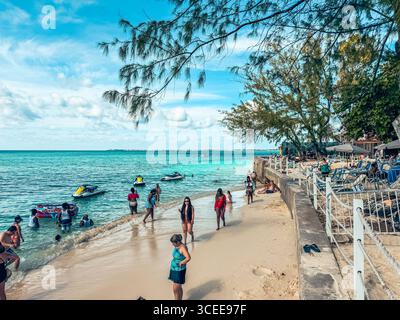 Grand Cayman, Isole Cayman - 1° gennaio 2025: Persone che si godono l'acqua lungo le spiagge della spiaggia di 11 km di Grand Cayman Foto Stock