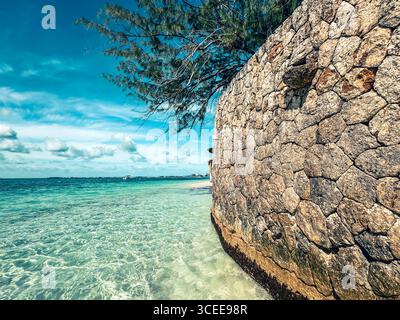 Grand Cayman, Isole Cayman - 1° gennaio 2025: Un muro di rottura rustico lungo l'acqua di Seven Mile Beach a Grand Cayman Foto Stock