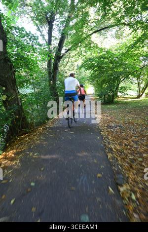 Usti nad Orlici, repubblica Ceca - 08162025 - ciclisti su un sentiero alberato circondato dal verde estivo Foto Stock
