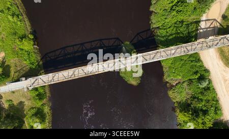 Vista dall'alto del drone sul ponte di ferro di Valmiera che attraversa il fiume Gauja, Lettonia Foto Stock