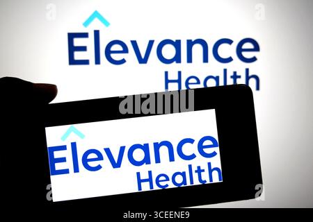 In questa immagine, un logo Elevance Health viene visualizzato su uno smartphone e sullo sfondo. Foto Stock
