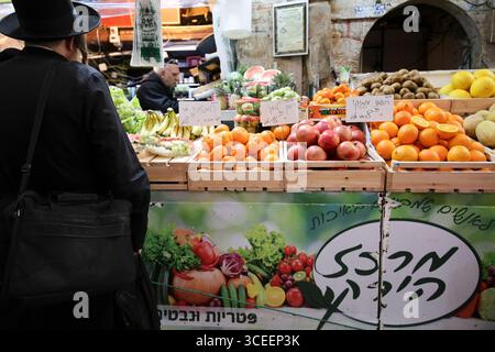 La gente compra frutta e verdura al mercato Mahane Yehuda a Gerusalemme il 12 febbraio 2025. Foto di Raquel G. Frohlich. Foto Stock
