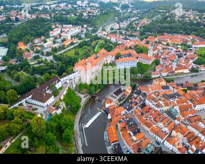 L'affascinante città di Cesky Krumlov è inondata di luce mattutina, con il suo iconico castello, i tetti colorati e il tortuoso fiume Moldava. Foto Stock