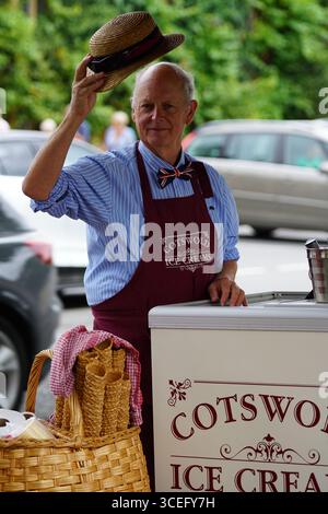 Uomo che gestisce un carrello per gelati in un mercato all'aperto. Bourton-on-the-Water, Inghilterra Foto Stock